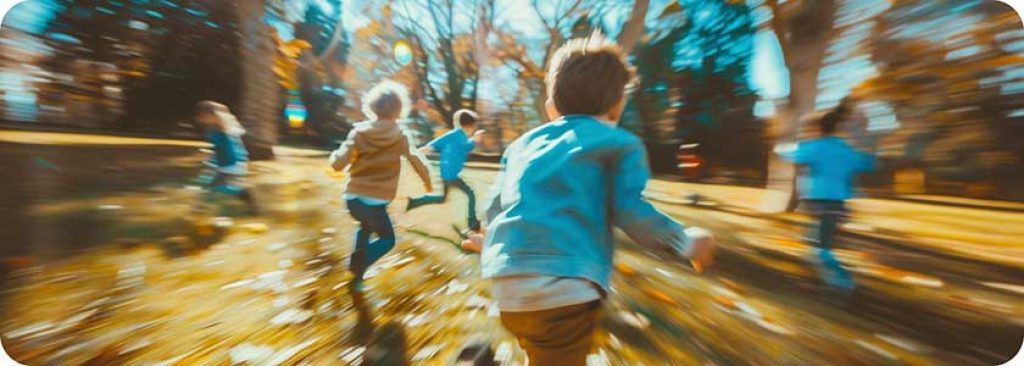 Children running wildly, with motion blur, in a cheerful setting, at the park.